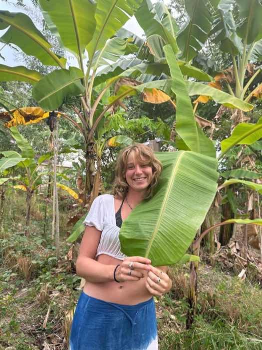 On the land, holding a banana leaf